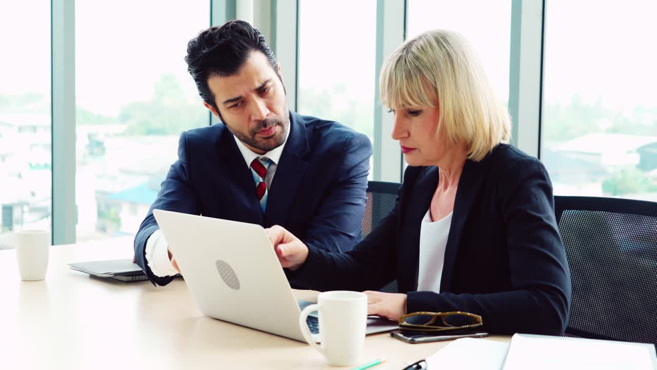 Due professionisti discutono la strategia del progetto in ufficio
