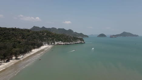 boats motor off natural sandy laem sala beach on coast of thailand