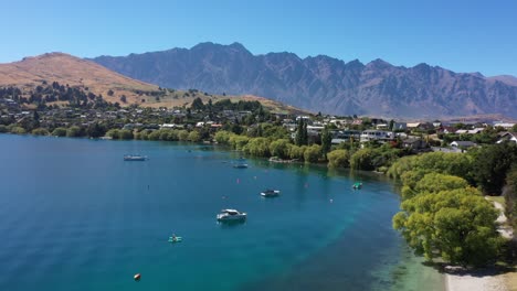 fotografía aérea de los lagos de queenstown nueva zelanda en un día perfecto de sol con kayaks en primer plano