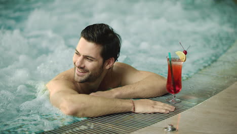 Portrait-of-sexy-guy-relaxing-in-pool-at-spa-hotel.-Happy-man-posing-in-jacuzzi