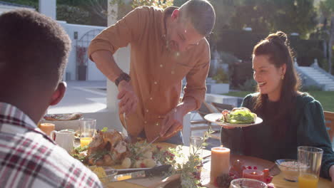 happy diverse male and female friends serving thanksgiving celebration meal in sunny garden