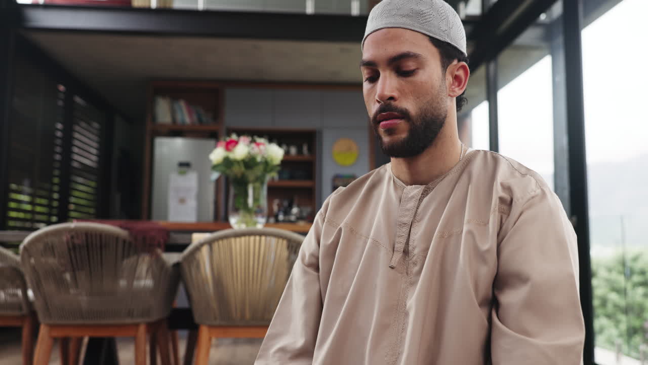 Ung muslimsk mand i traditionel beklædning mediterer fredfyldt derhjemme