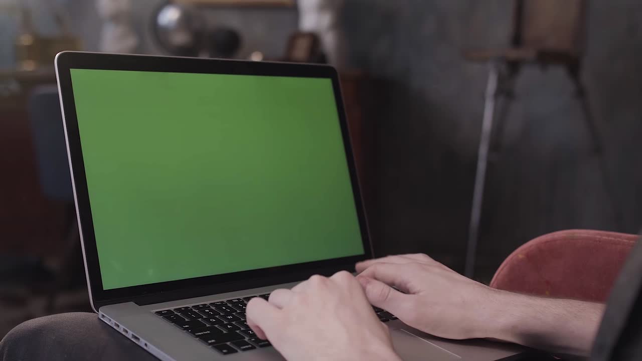 persona trabajando en una computadora portátil con una pantalla verde