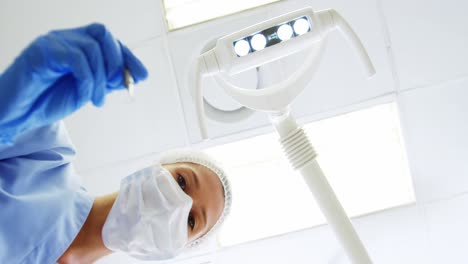 asistente dental sosteniendo una herramienta dental