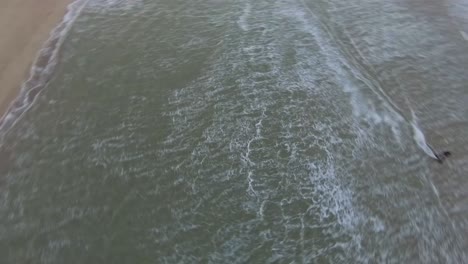 Fast-aerial-shot-of-a-kitesurfer-going-through-a-lagoon-in-the-North-Sea