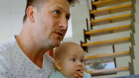 padre y bebé viendo televisión en la sala de estar 4k