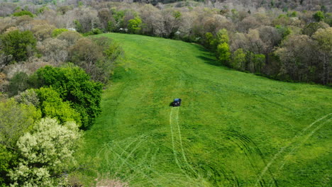 vehicle driving on the green field during land survey near siloam springs, arkansas, usa - aerial shot