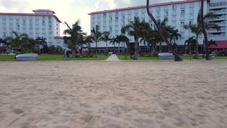 low angle pull away drone shot of beachfront of crown plaza resort