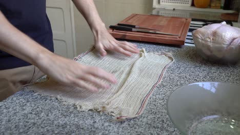 Un-Hombre-En-La-Cocina-Colocó-Un-Paño-Húmedo-Debajo-De-Una-Tabla-De-Cortar-De-Madera