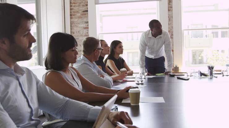 Des professionnels écoutent une présentation en salle de conseil, filmé en R3D
