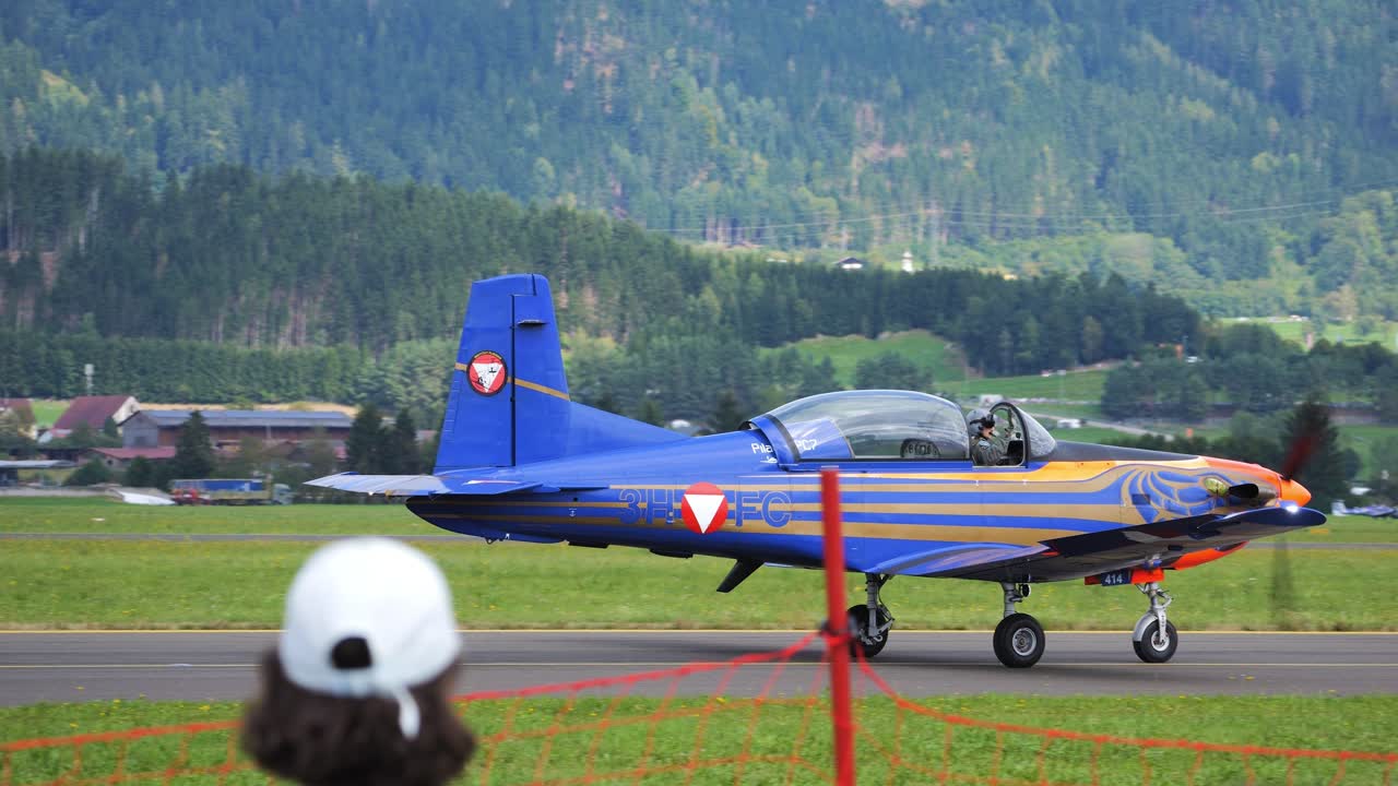 Aerobatic pilot taxis over the runway at Airpower 2024 in Austria while waving to the spectators. Slow motion