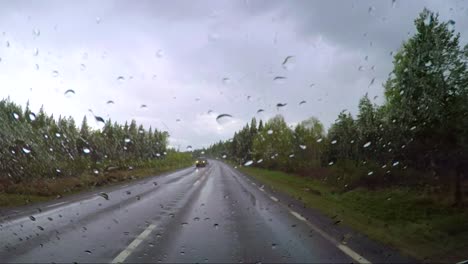 view from the car in the rain driving on wet roads. driving a car on a road in norway