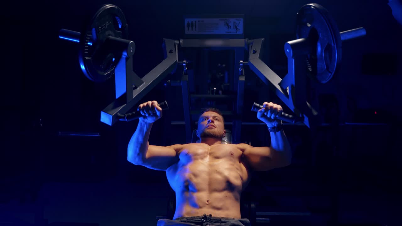 Bodybuilder che si allena in palestra. Uomo forte durante l'esercizio con un programma di allenamento per la salute.