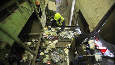 high angle view of workers sorting trash at a recycling center