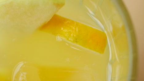 cóctel amarillo con hielo y fruta