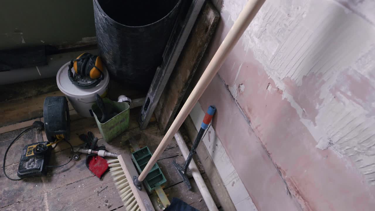 Bathroom renovation; orbit shot looking down on DIY tools in stripped back room during daytime