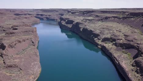 aerial tilt over deep lake in dramatic arid landscape of central wa