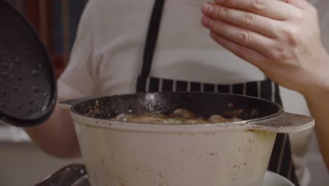 chef tastes the smell coming from opened cooking pot