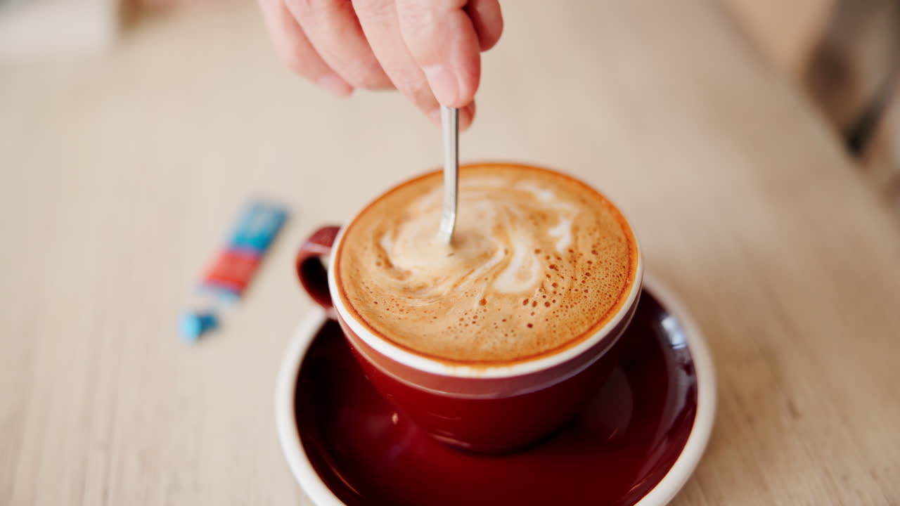 Person stirring coffee with a spoon