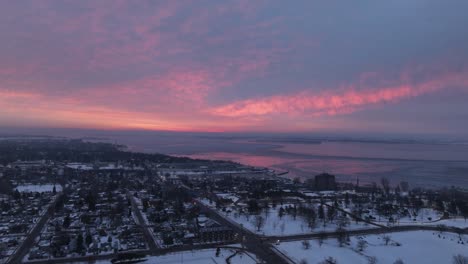 timelapse aéreo de un amanecer de cielo rojo sobre un paseo marítimo de la ciudad