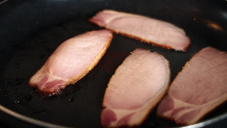 cocinar tocino casero en rodajas en una sartén