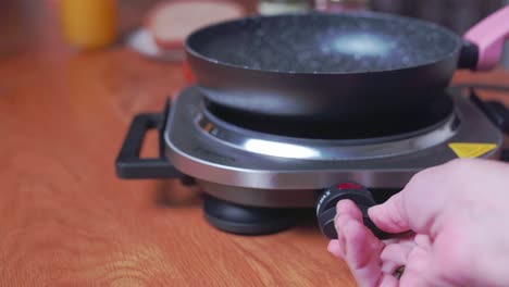 Hand-demonstrating-timer-dial-on-countertop-electric-stove