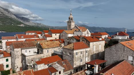 a view of korčula's historic town with stone buildings and orange rooftops by the sea