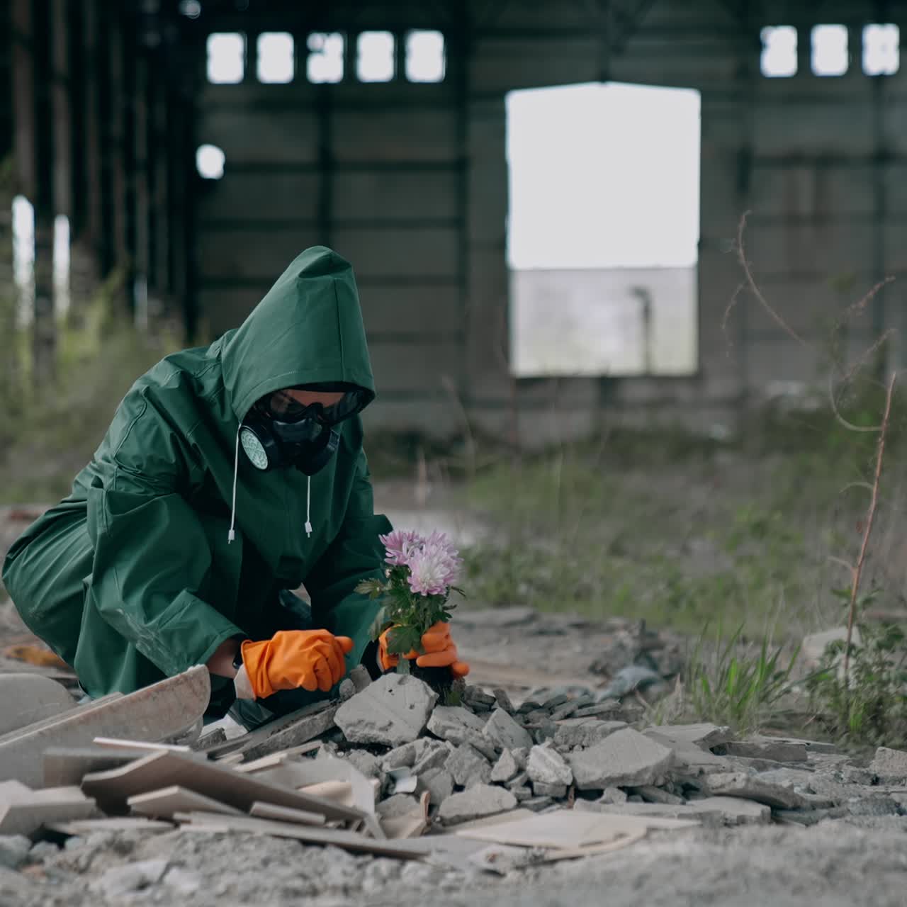 Ecologist plants flowers into stones. Man in a gas mask protects the plant after an environmental disaster. Chemical attack