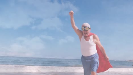 Animation-of-clouds-over-senior-caucasian-man-wearing-superhero-costume-on-beach