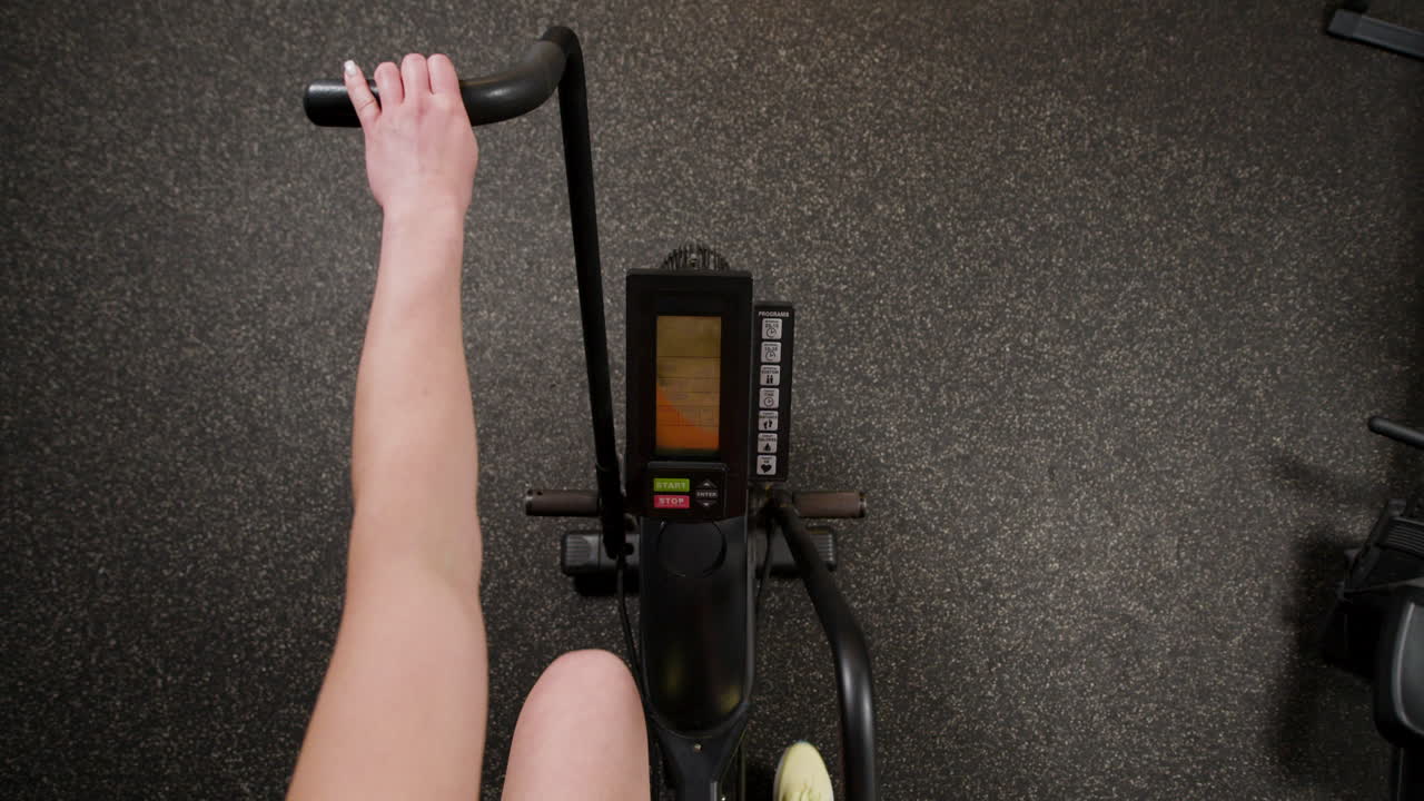 Person using an exercise bike at the gym