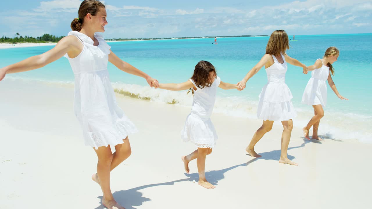 백인 어머니 와 딸 들 이 열대 해변 에서 산책 하고 있다