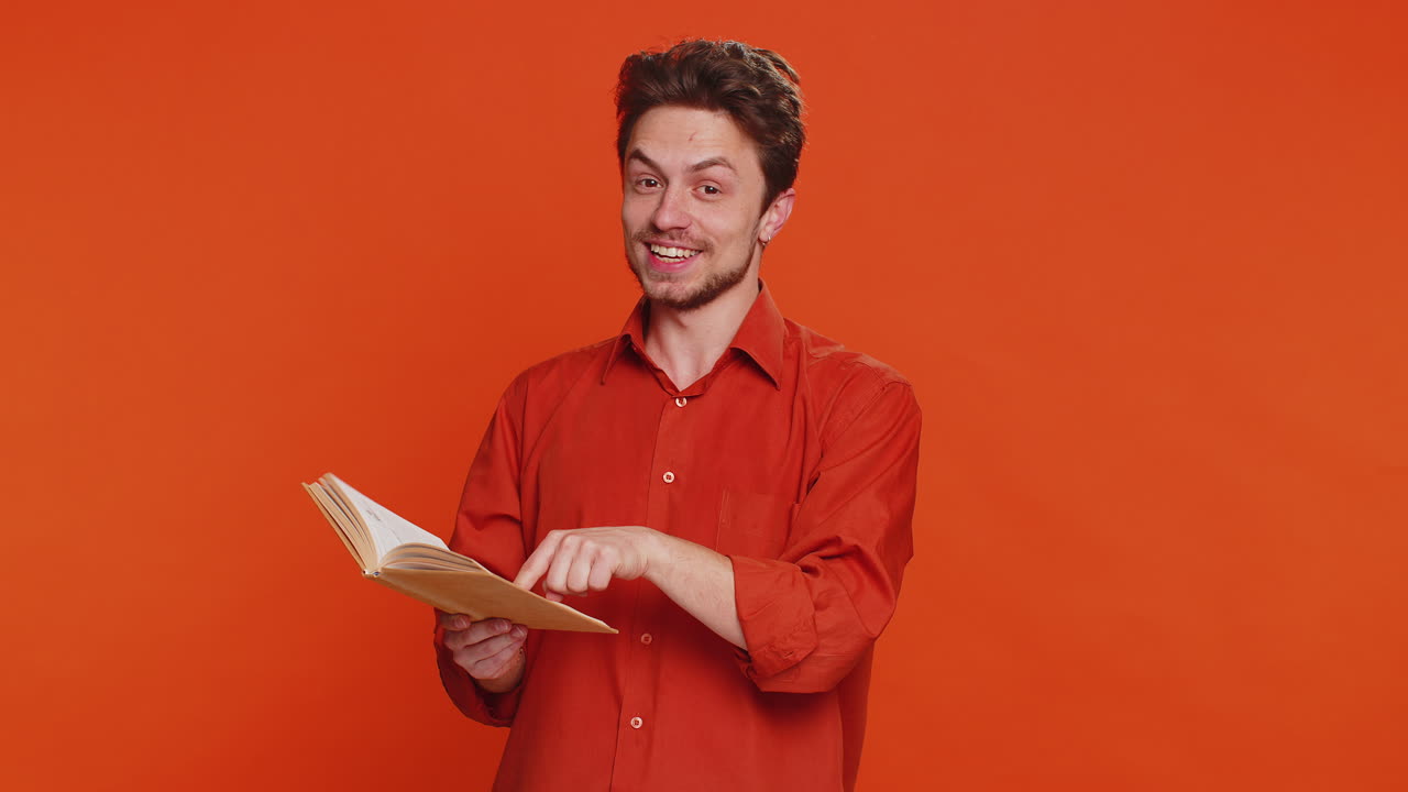 Happy caucasian man reading funny interesting fairytale story book leisure hobby learning study