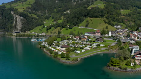 an aerial shot of a small, cozy campground in the swiss village of sisikon, located on lake lucerne, on a sunny summer day