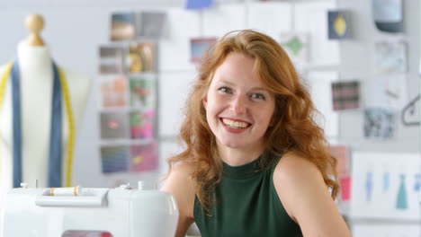 retrato de una estudiante o propietaria de una empresa que trabaja en la industria de la moda usando una máquina de coser