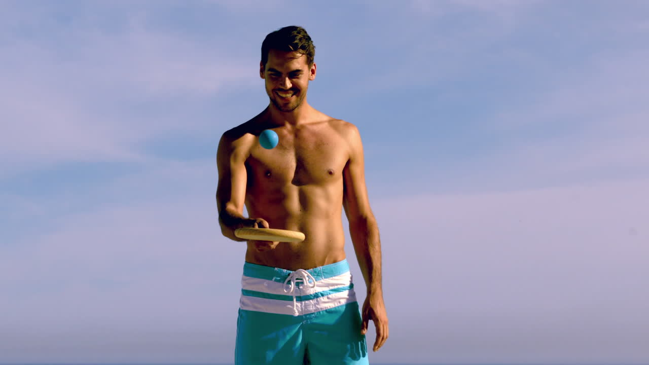 셔츠 없는 남자 가 라켓 에 공 을 뛰고 있다