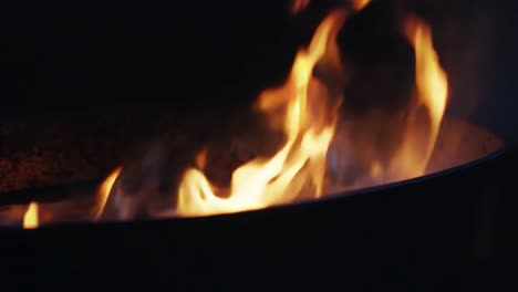close up of flames burning in a fire pit at night