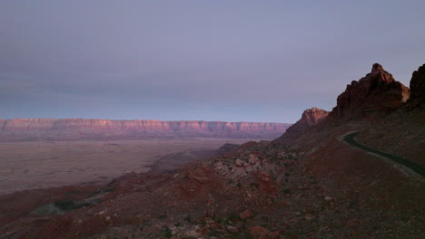 Drone-shot-at-day-break-of-road-cut-into-canyon-in-the-southwest