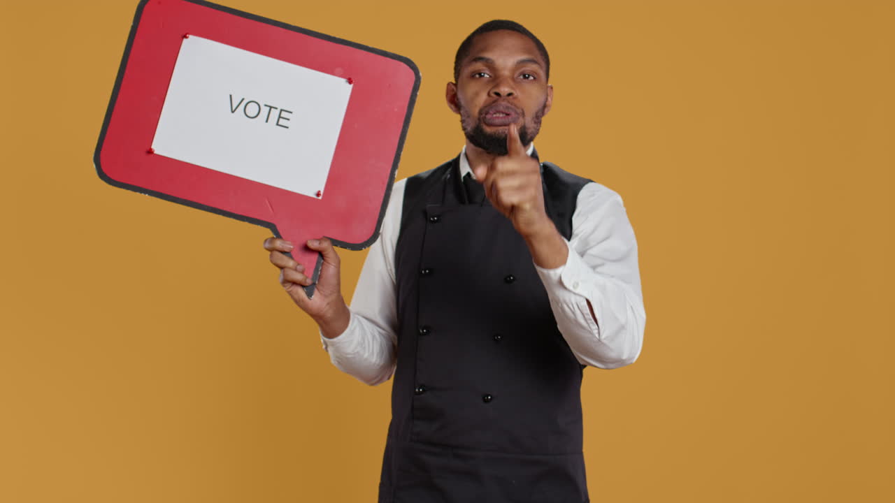 Catering employee showing a message to vote on red speech bubble