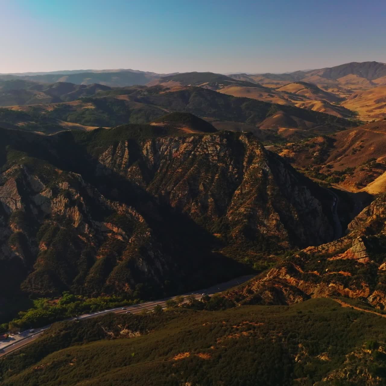 Splendido paesaggio montuoso in una giornata di sole da qualche parte negli Stati Uniti. Strada che attraversa le montagne con molte auto. Vista aerea