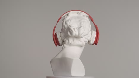 ancient bust with red headphones