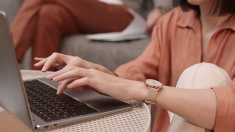 manos femeninas escribiendo en el teclado del portátil