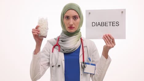 female doctor in hijab holds 'diabetes' sign and sugar cubes, raising health awareness