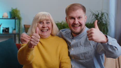 Happy-senior-grandmother-with-grandson-man-showing-thumbs-up,-like-positive-sign,-good-news-at-home