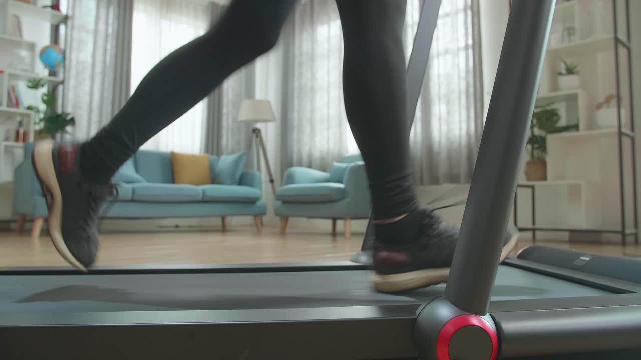 Side View Legs Of Asian Woman Running On A Treadmill At Home