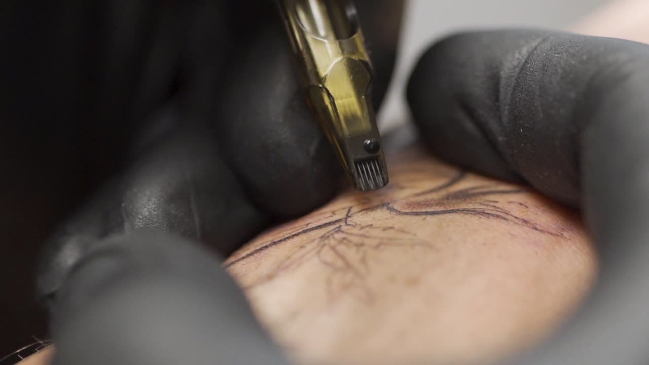 Macro shot of tattooing process with large needles in a professional tattoo studio. Shot in slow motion 120fps