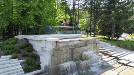 waterfall in park during a beautiful summer day surrounded by lush greenery and grass