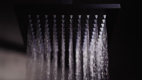 water flows from a black square nozzle in the shower. 4k slow motion video