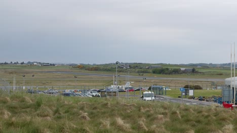 Shot-of-a-small-passenger-airplane-flying-then-landing-on-a-runway-on-a-wet-and-windy-day