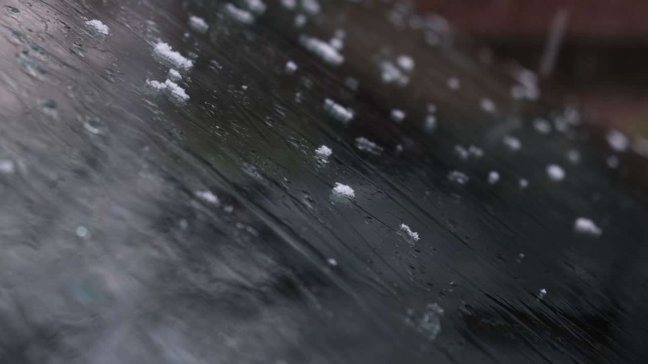 차 창문에 눈이 녹고 있습니다.