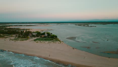 Toma-Aérea-De-La-Playa-Y-El-Río-Al-Atardecer,-Colombia,-La-Guajira